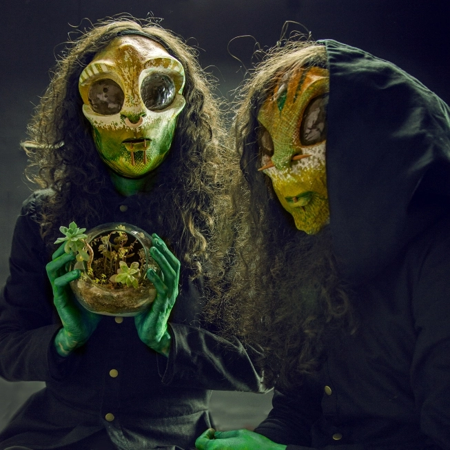 Losaquis tribal aliens holding a planet, symbolizing creation, connection to Earth, and the birth of an alien universe through music and art.