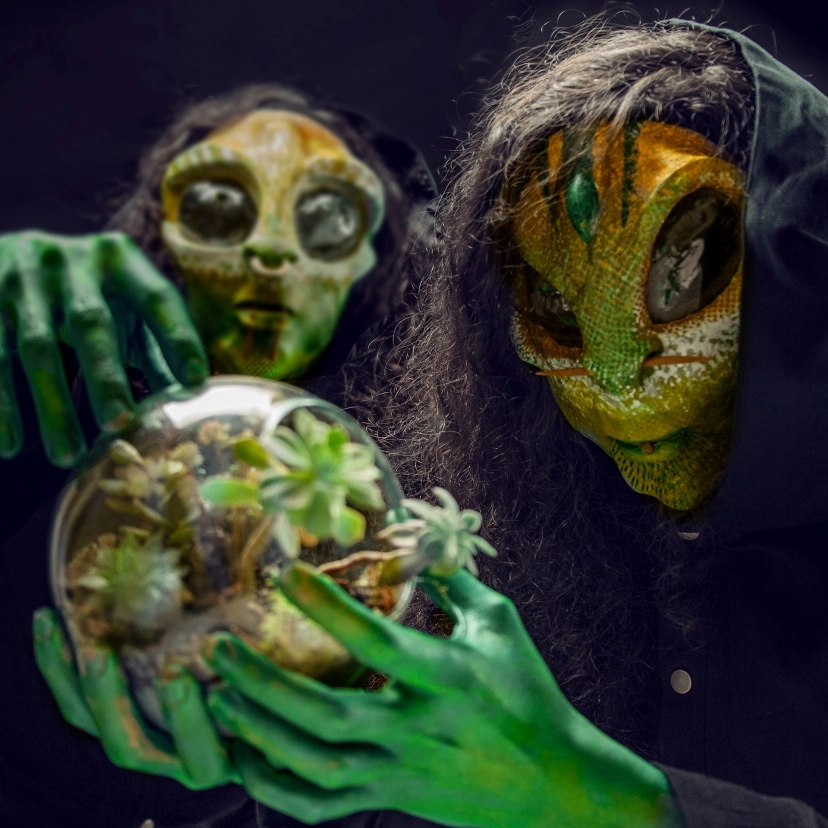 Losaquis holding and observing a glowing planet in their hands, symbolizing alien connection, cosmic power, and ancestral vision